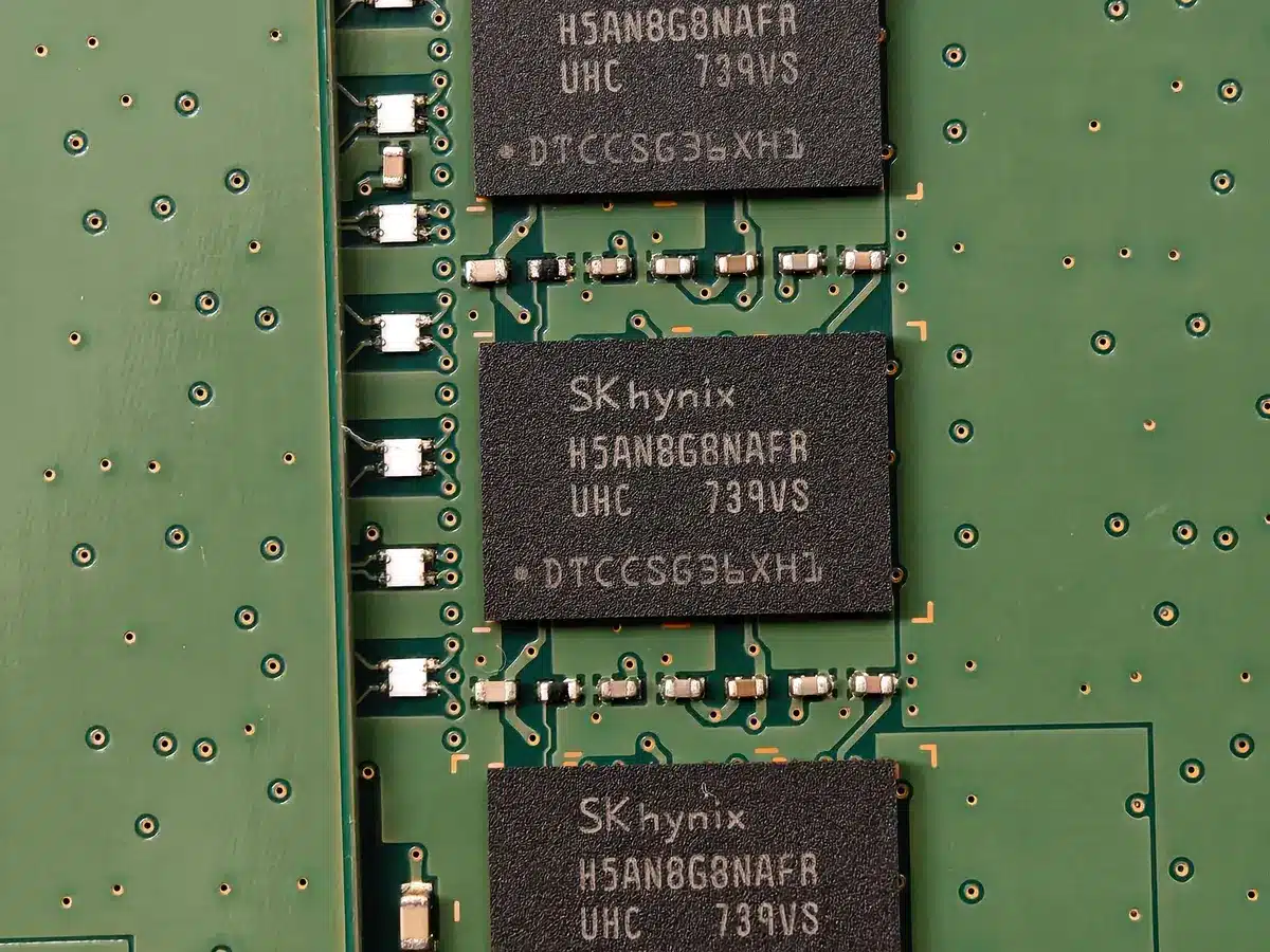 Postazione di lavoro con schemi di design di chip e componenti elettronici illuminati da interfaccia AI