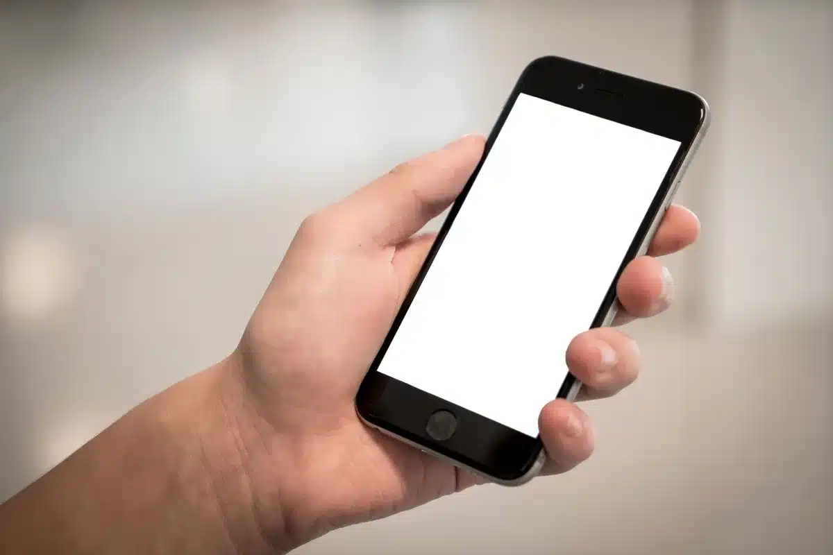 Una mano che impugna uno smartphone moderno mostrando come i dita potrebbero toccare involontariamente i bordi