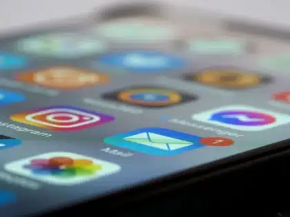 Mano che tiene uno smartphone con notifiche di messaggi e aggiornamenti sullo schermo