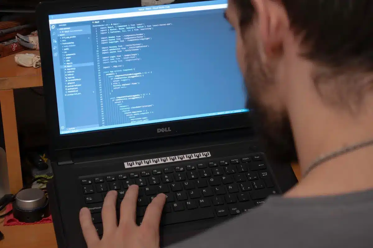 Sviluppatore al lavoro al computer con codice sullo schermo