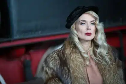 Donna elegante in profilo con luci di Hollywood sullo sfondo e schermi televisivi vintage