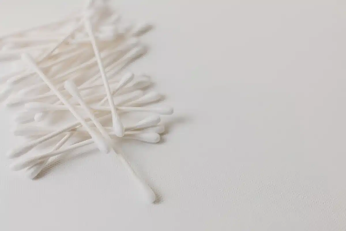 Panno morbido accanto a cotton fioc e oggetti da non usare per asciugare