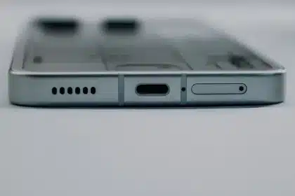 Goccia d'acqua sopra la porta di ricarica di uno smartphone su superficie bianca