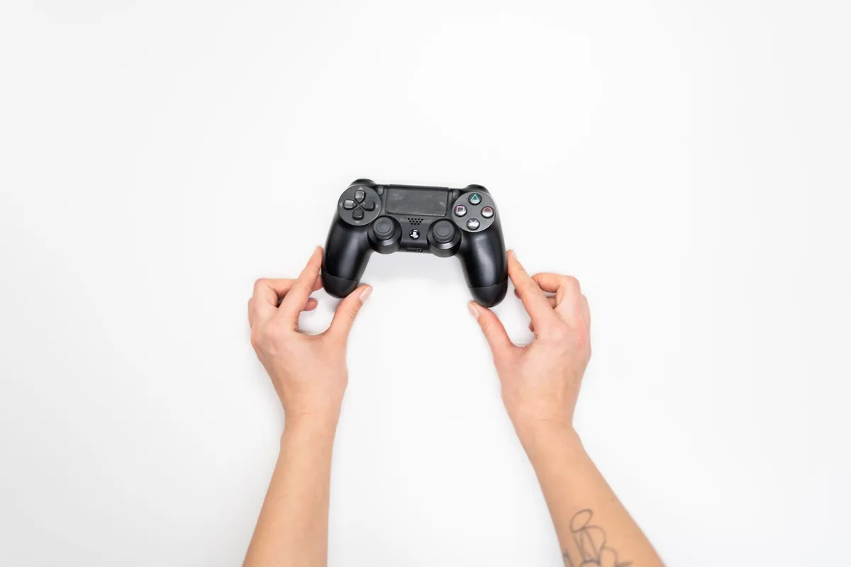 Mano che impugna un controller da gioco durante una sessione di gioco d'azione