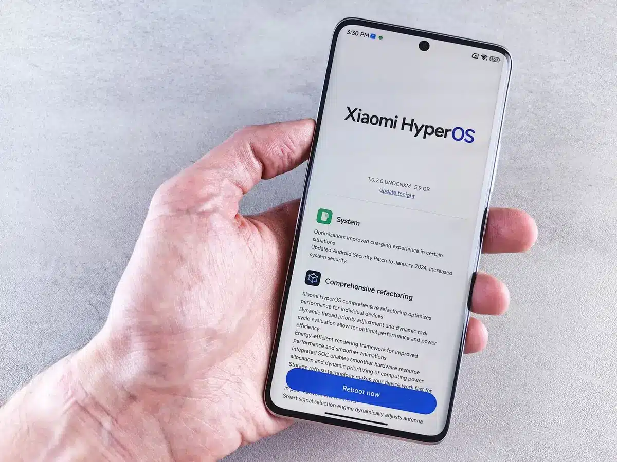 Schermo di uno smartphone che mostra specifiche tecniche e dati di batteria in un ambiente di lavoro moderno