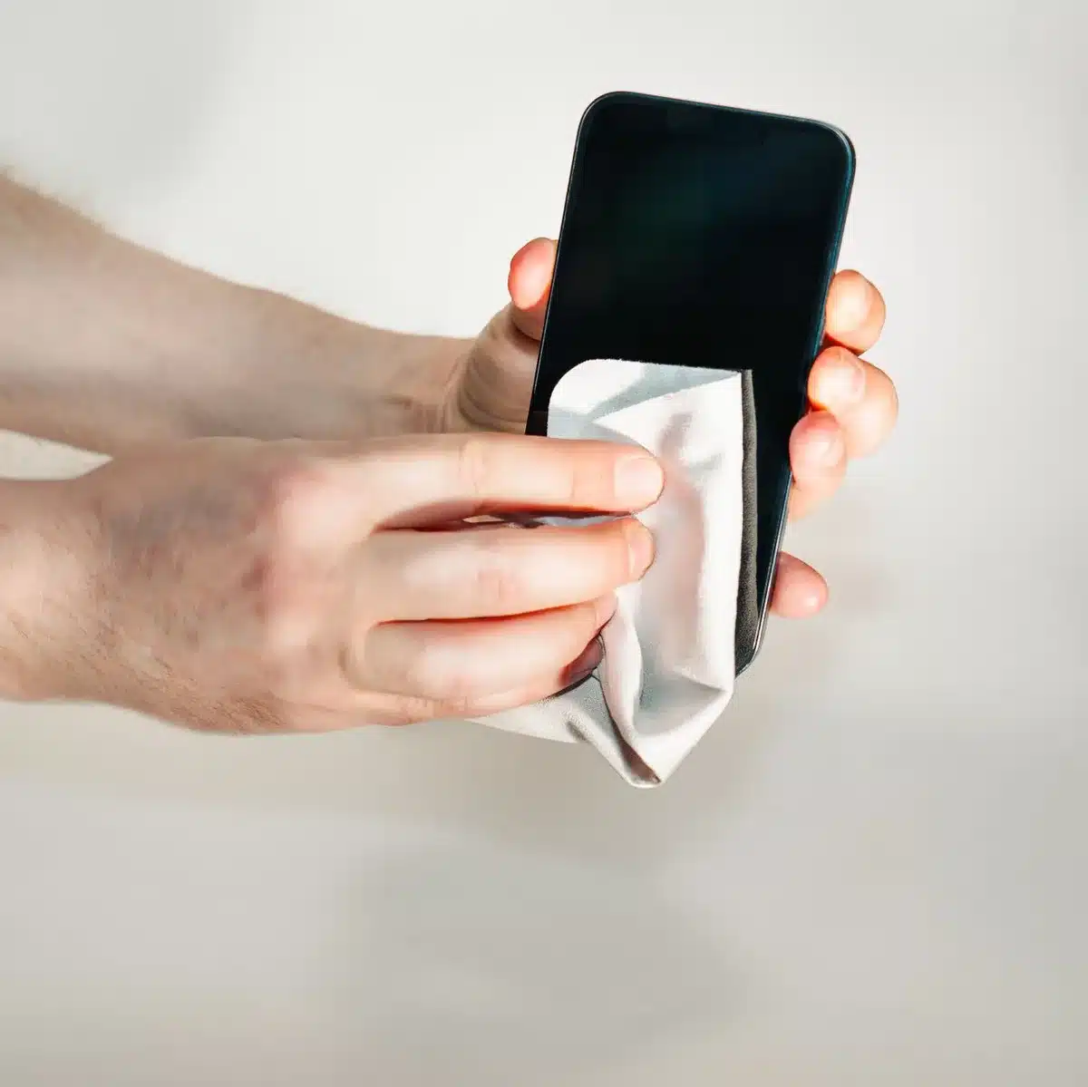 Smartphone che viene delicatamente sciacquato con acqua dolce e asciugato con panno in microfibra