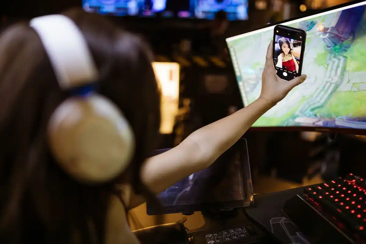 Schermo di smartphone che mostra app di gioco e video in riproduzione, simbolo di processore sotto carico