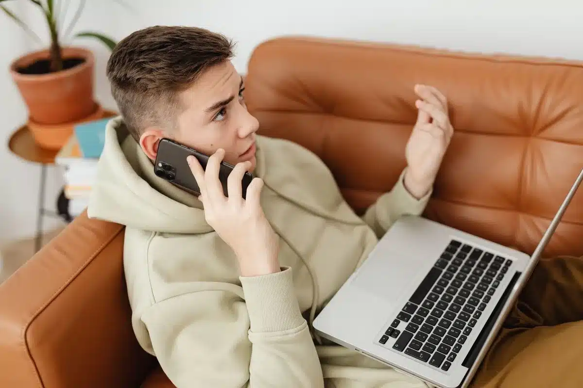 Persona al telefono con espressione diffidente, bolletta energetica visibile sul tavolo