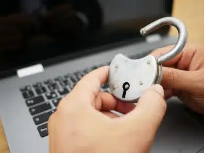 Tastiera e schermi con codice e avvisi di sicurezza in un ambiente di ufficio al buio