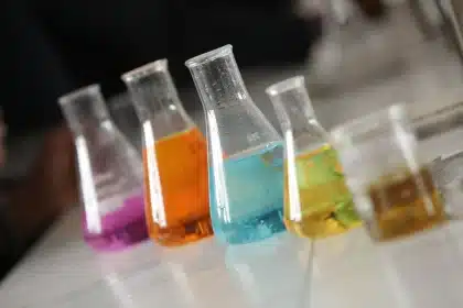 Laboratorio scientifico con modelli molecolari, schermi di computer e documenti di ricerca illuminati da luce blu.