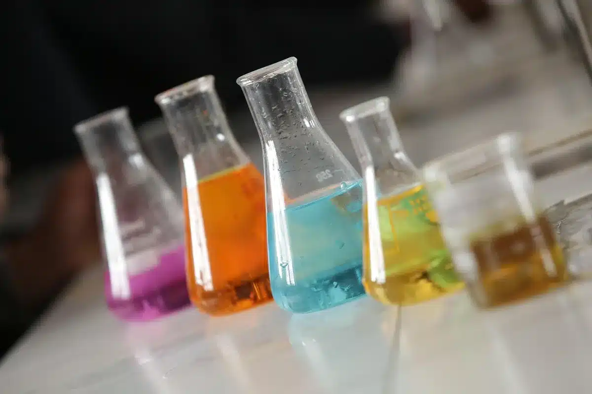 Laboratorio scientifico con modelli molecolari, schermi di computer e documenti di ricerca illuminati da luce blu.