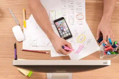Due figure anonime davanti a una lavagna con schemi di game design in uno studio
