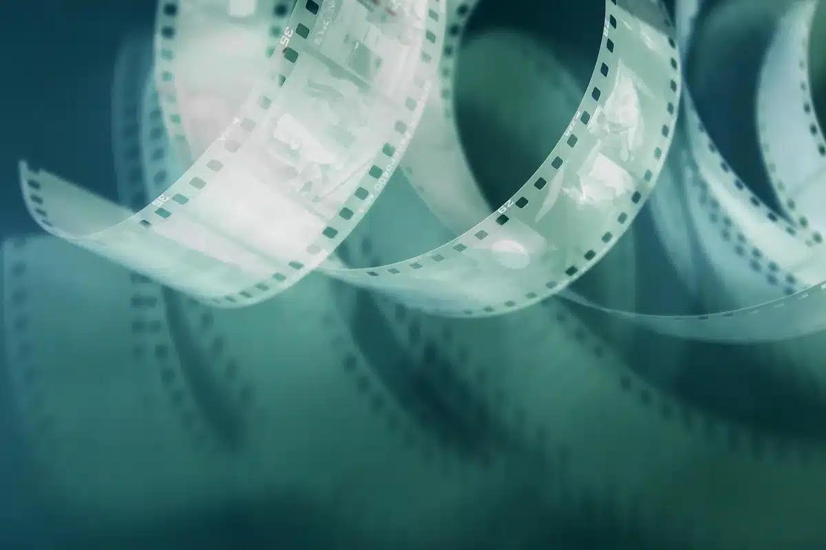 Bobina di pellicola 35mm e attrezzatura di ripresa analogica su tavolo da lavoro