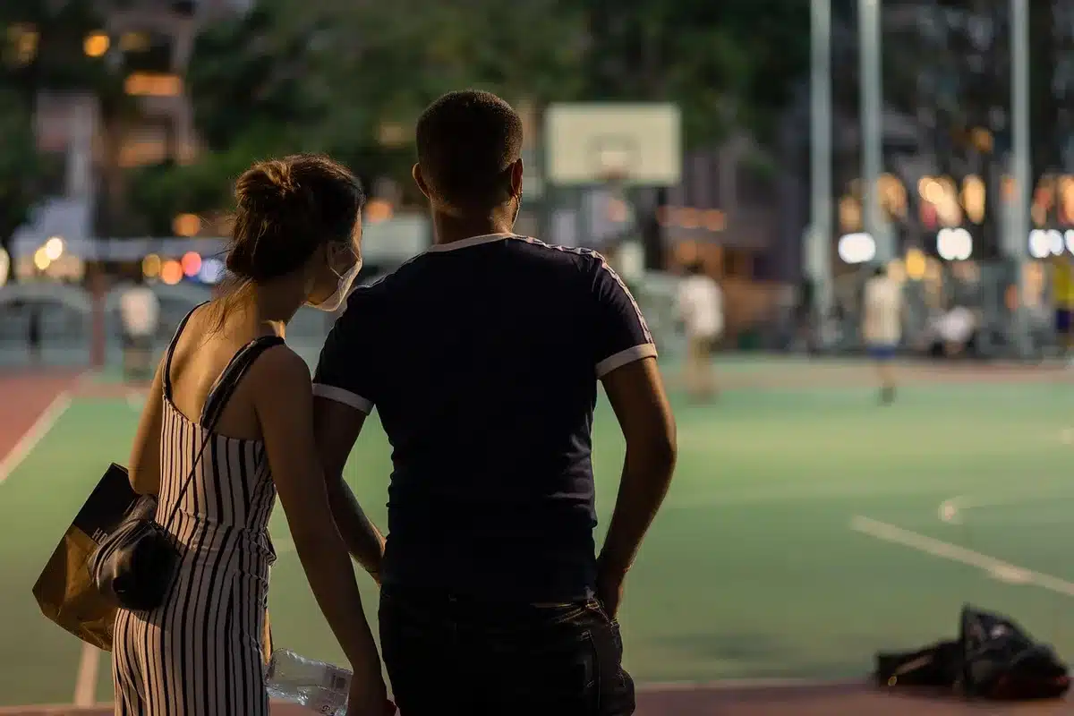 Coppia in un momento di intimità romantica con luci cittadine sullo sfondo