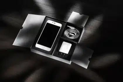 Smartphone anon con cavo USB-C collegato a un caricatore su scrivania