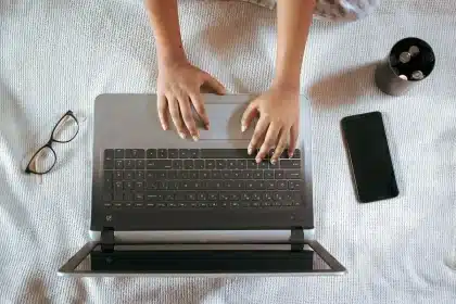 Mani anonime che tengono uno smartphone pieghevole in uno studio luminoso
