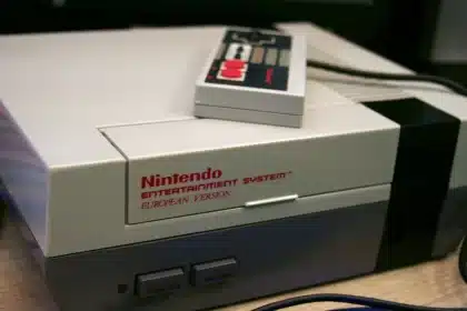 Mani che impugnano un controller retrò davanti a uno schermo con giochi platform classici