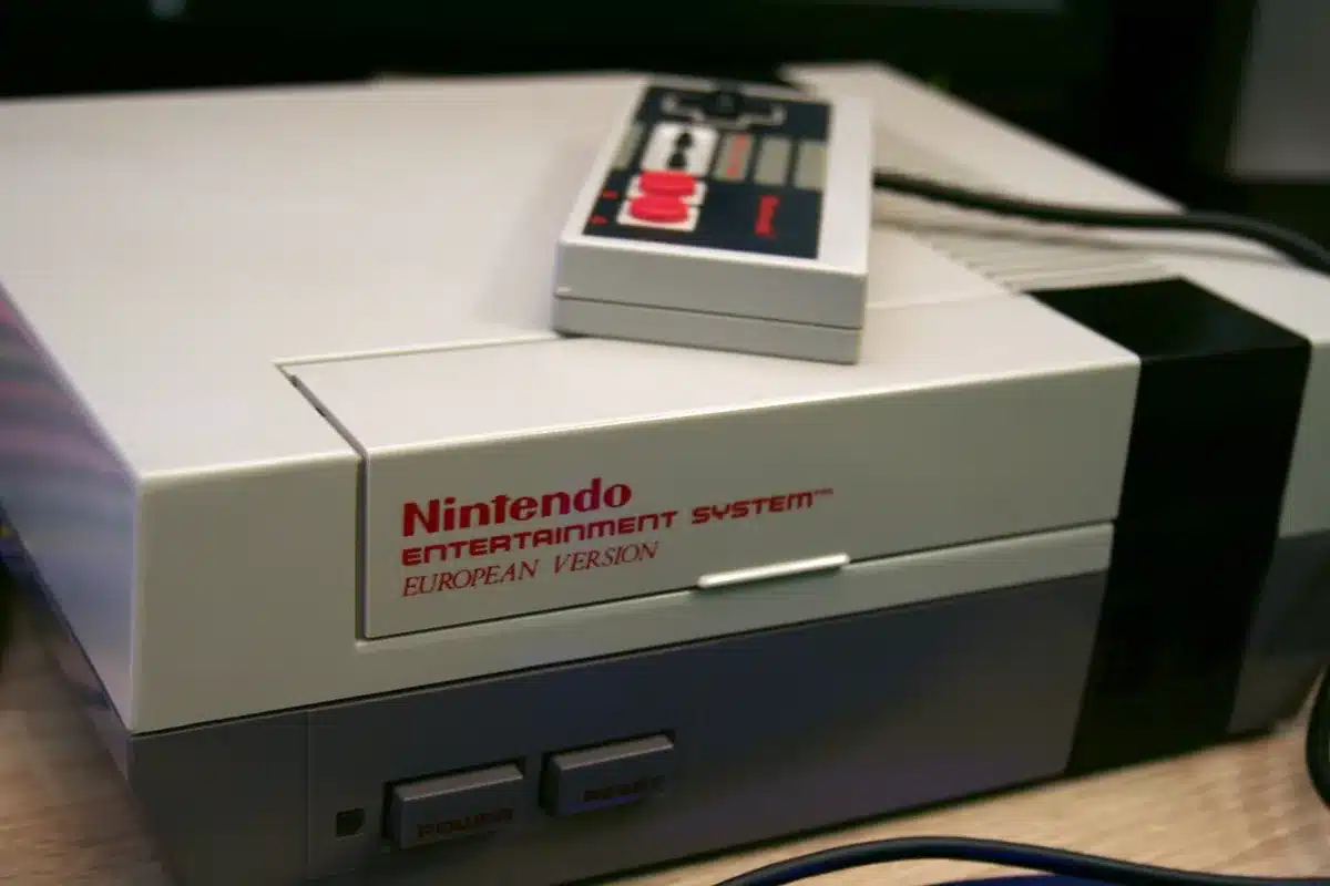 Mani che impugnano un controller retrò davanti a uno schermo con giochi platform classici