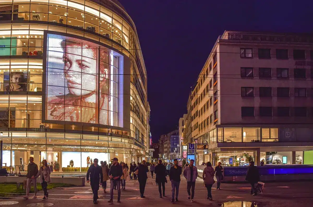 Auto da corsa di notte in una strada urbana illuminata da luci al neon, con grattacieli sullo sfondo