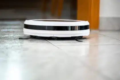 Robot aspirapolvere intelligente che pulisce un salotto moderno con giocattoli e ciotole per animali
