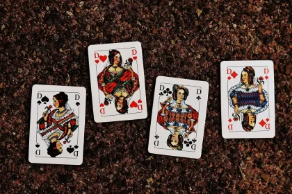 Mani di giocatore che dispongono carte da gioco su un tavolo con simboli e artwork tematici