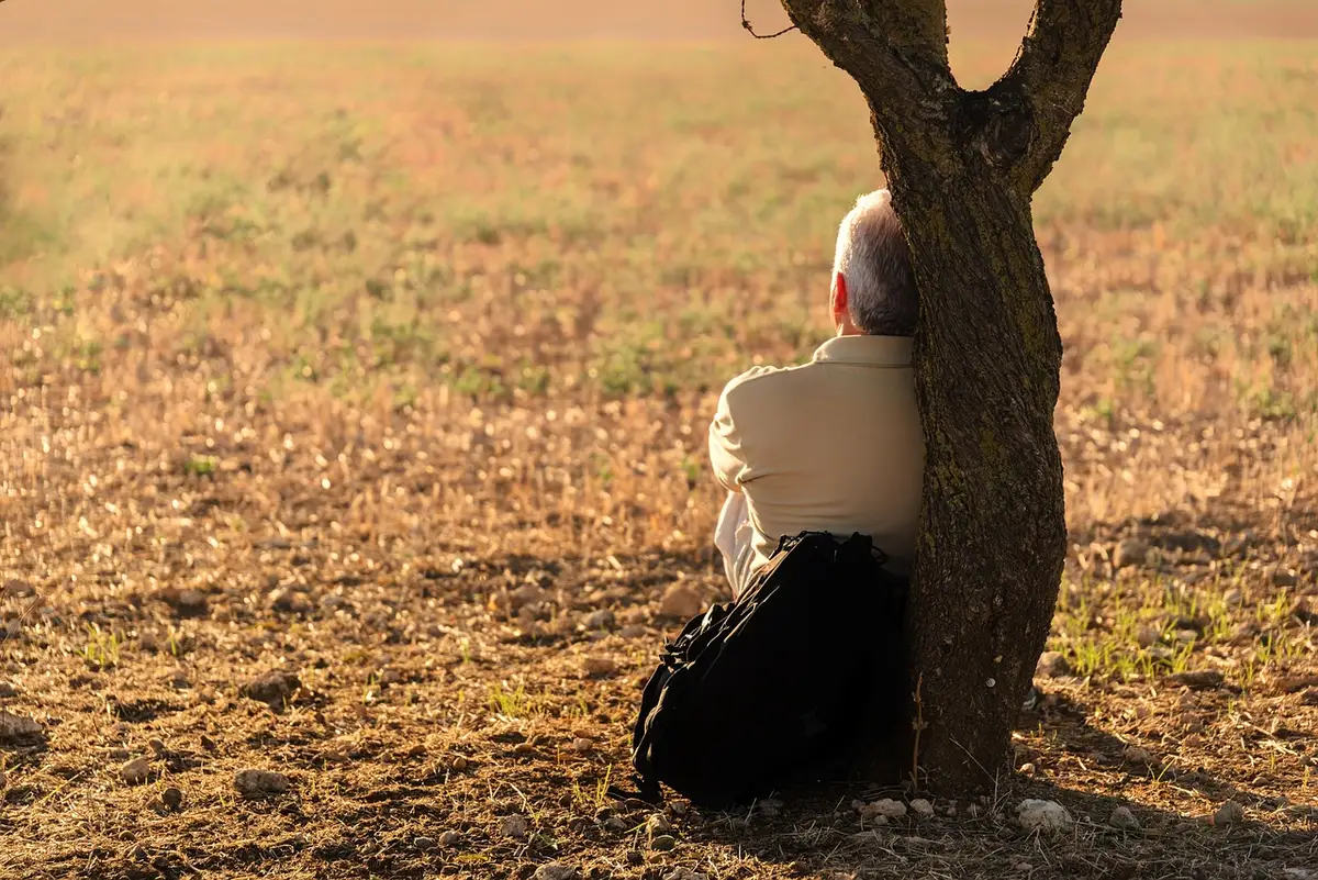 Figura solitaria in ambiente rurale che rappresenta l'isolamento emotivo del protagonista