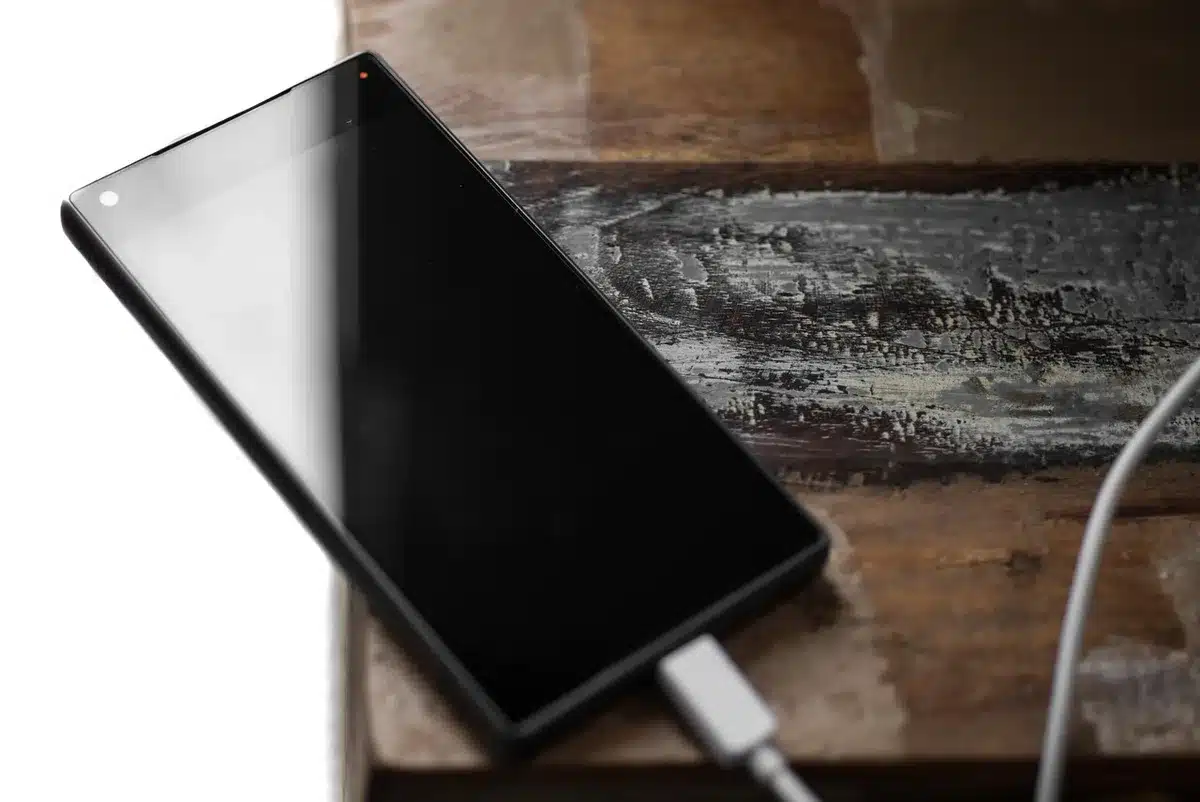 Smartphone con cavo di ricarica e icona batteria grande