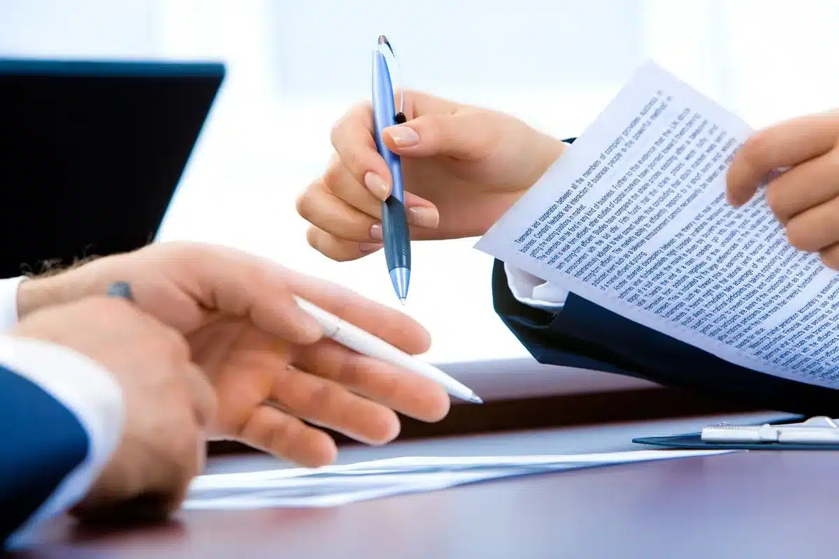 Mano che indica documenti sulle azioni in una riunione aziendale