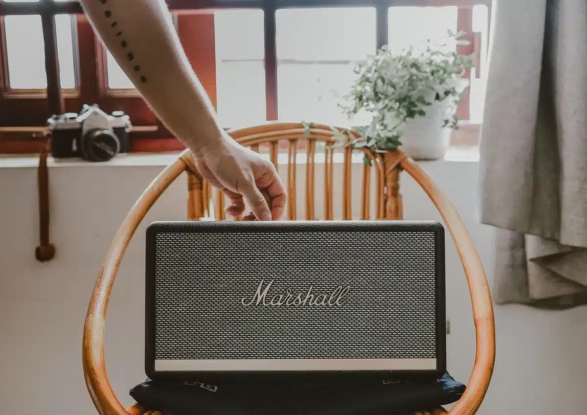 Speaker resistente posato su sasso vicino a una borraccia, indicazione outdoor