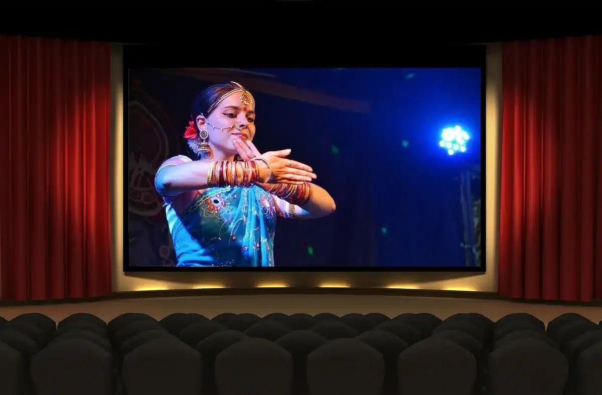Un palcoscenico vuoto con luci calde che evoca il teatro dove iniziò Zamuto