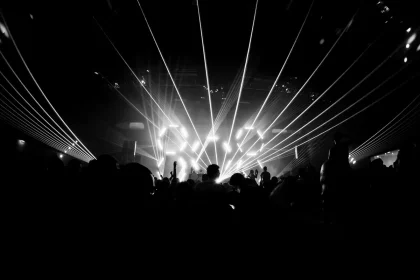 Giovani spettatori in silhouette in una sala festival con premi su un tavolo