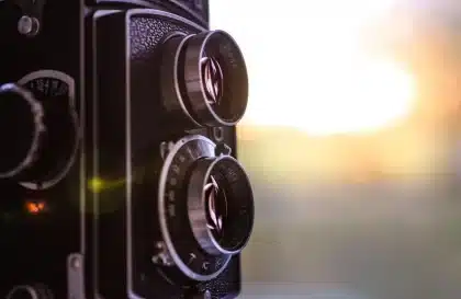 Mano anonima che tiene una bobina di film su un tavolo con foto di scena