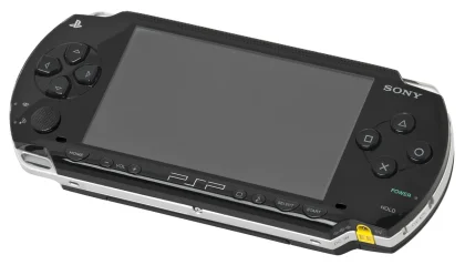 Mani che tengono una console portatile con una cartuccia di gioco su un tavolo