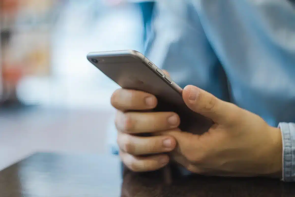 Persona che guarda uno smartphone con filtro privacy in pubblico