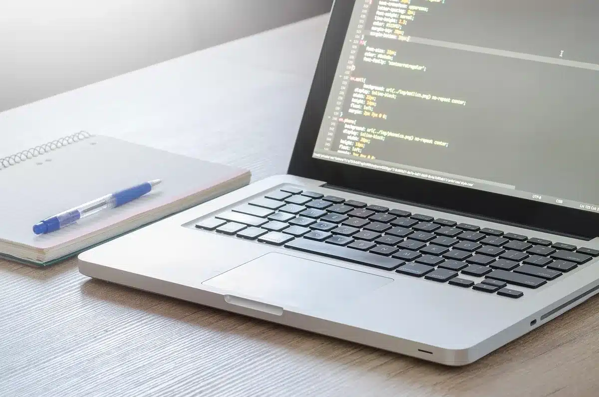 Sviluppatore davanti a monitor con codice e icone cloud per agenti