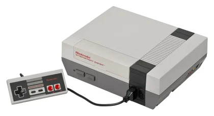 Mano che tiene una custodia di gioco vuota vicino a una console su un tavolo