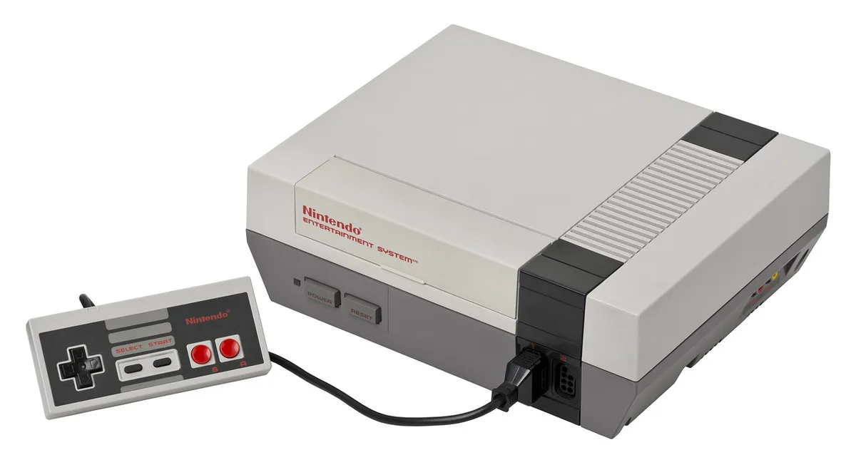 Mano che tiene una custodia di gioco vuota vicino a una console su un tavolo